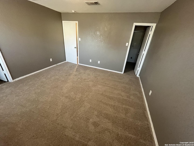 unfurnished bedroom featuring carpet floors, visible vents, and baseboards