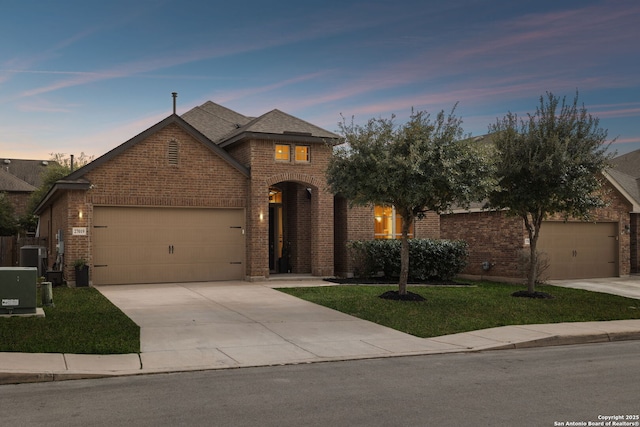 view of front of house featuring a front lawn, concrete driveway, brick siding, and an attached garage