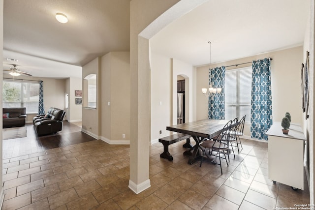 dining space featuring arched walkways, visible vents, baseboards, and ceiling fan with notable chandelier