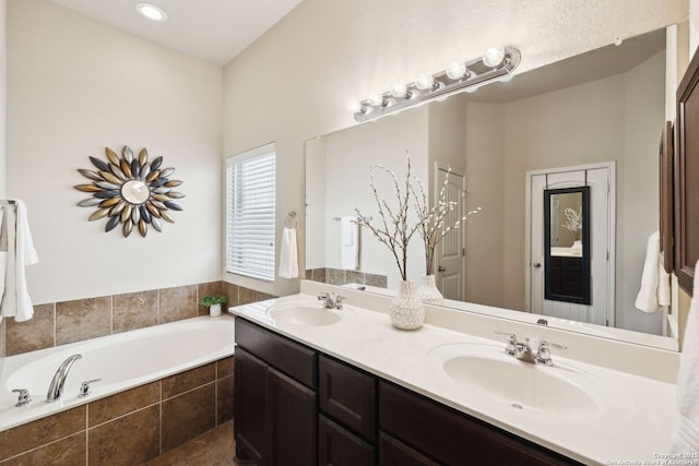 full bath with a garden tub, a sink, and double vanity