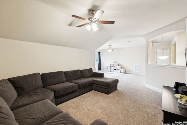 carpeted living room featuring a ceiling fan, lofted ceiling, visible vents, and baseboards