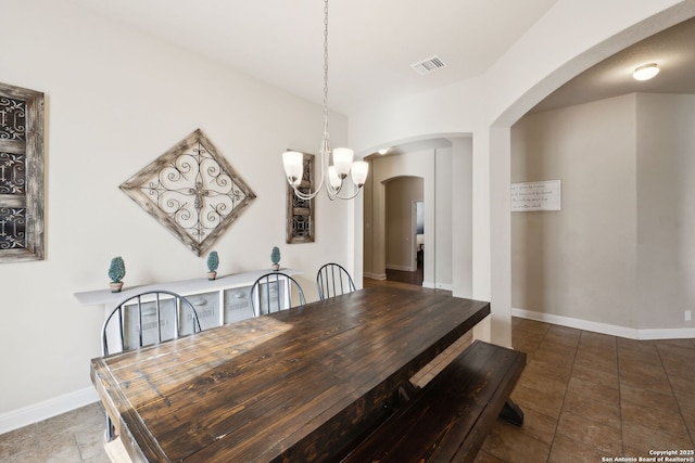 dining room featuring an inviting chandelier, baseboards, visible vents, and arched walkways