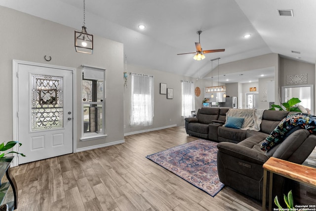 living room with visible vents, baseboards, vaulted ceiling, a ceiling fan, and light wood-type flooring