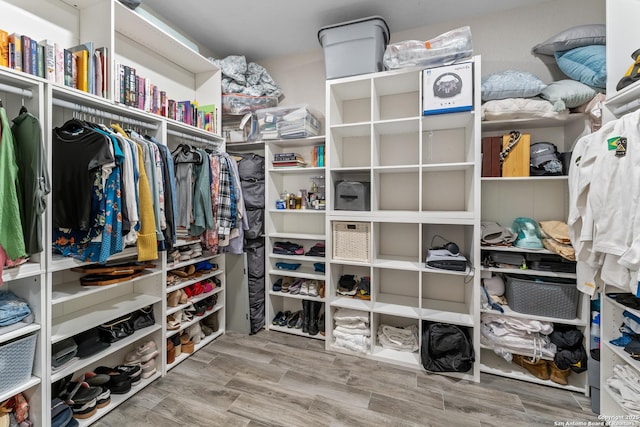 walk in closet with wood finish floors