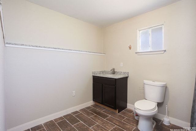 620 County Road 6846, Lytle, TX 78052 - half bath featuring toilet, baseboards, wood finish floors, and vanity