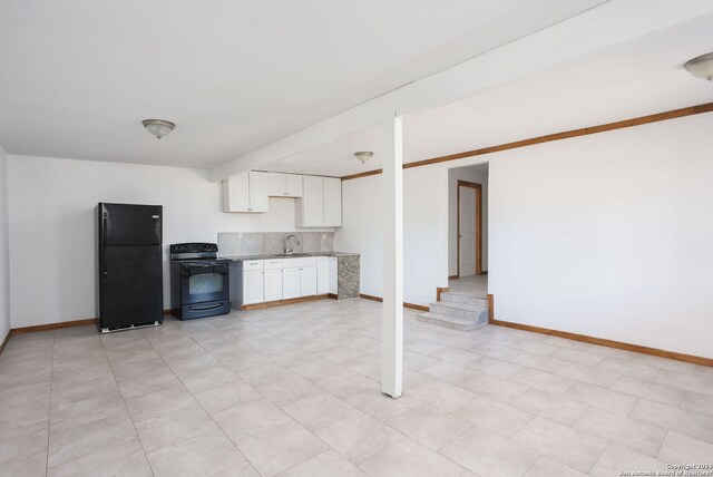 620 County Road 6846, Lytle, TX 78052 - kitchen featuring decorative backsplash, white cabinetry, a sink, black appliances, and baseboards