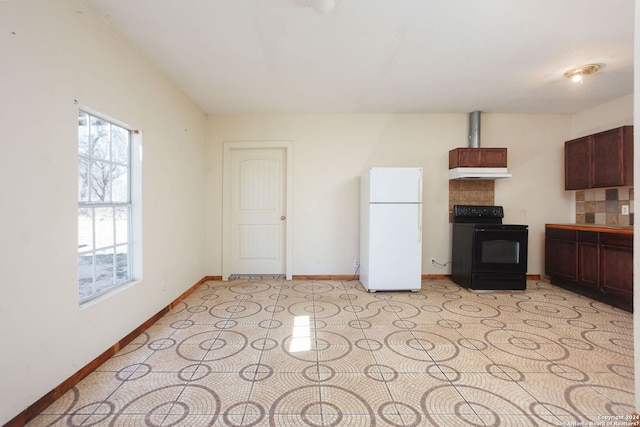 620 County Road 6846, Lytle, TX 78052 - kitchen with under cabinet range hood, baseboards, black range with electric stovetop, and freestanding refrigerator
