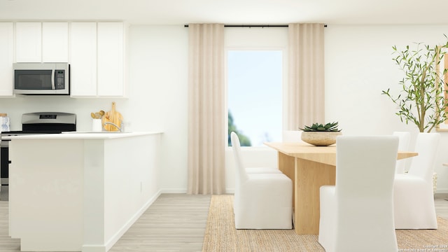 kitchen with baseboards, stainless steel appliances, light wood-type flooring, and white cabinets