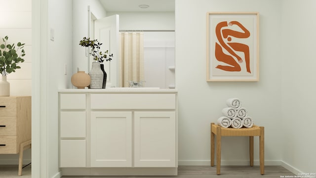 bathroom with a shower with curtain, wood finished floors, vanity, and baseboards