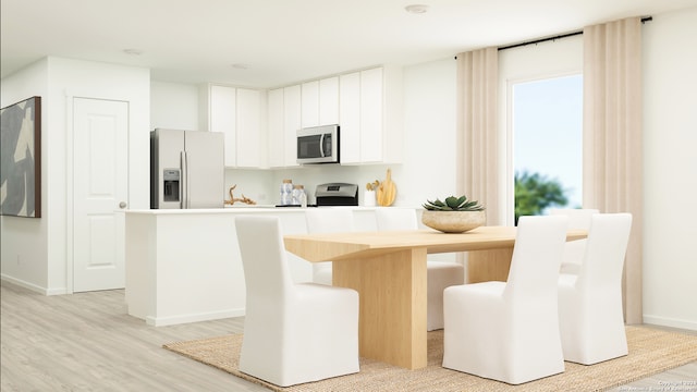 kitchen with light wood finished floors, stainless steel microwave, white cabinets, white fridge with ice dispenser, and range