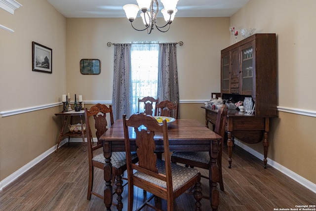 dining area with baseboards, dark wood finished floors, and a notable chandelier