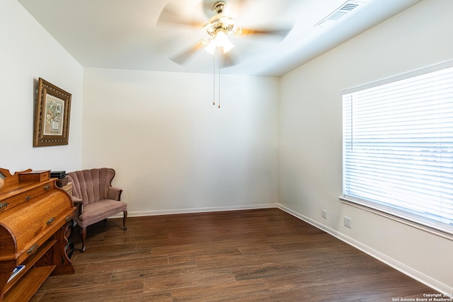 sitting room with a ceiling fan, dark wood-style flooring, visible vents, and baseboards