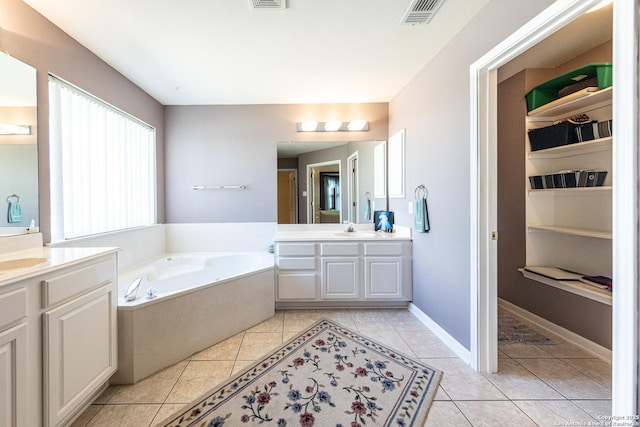 bathroom featuring a garden tub, two vanities, visible vents, a sink, and tile patterned flooring