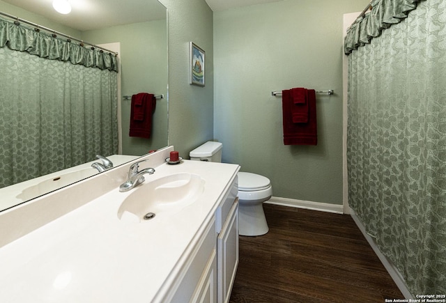 bathroom featuring vanity, wood finished floors, toilet, and baseboards