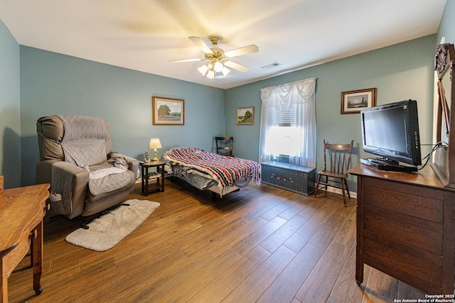 bedroom featuring visible vents, ceiling fan, and wood finished floors