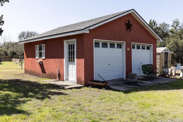 detached garage featuring fence