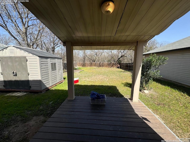 deck featuring a storage shed, a fenced backyard, an outbuilding, and a yard