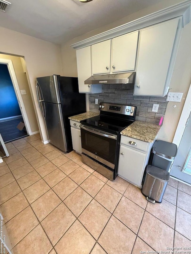 kitchen with light tile patterned flooring, under cabinet range hood, stainless steel appliances, visible vents, and backsplash