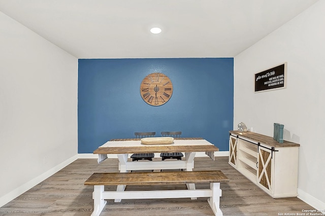 dining room with baseboards, wood finished floors, and recessed lighting