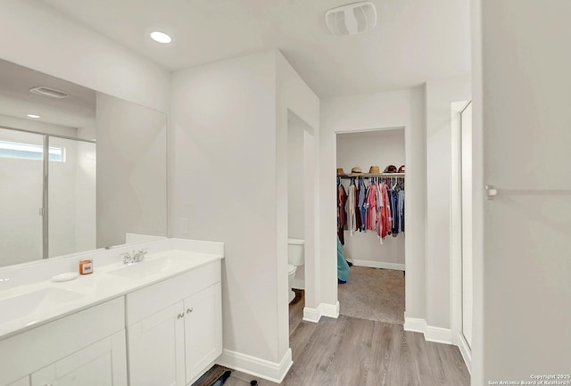 full bathroom featuring a shower stall, visible vents, a sink, and wood finished floors