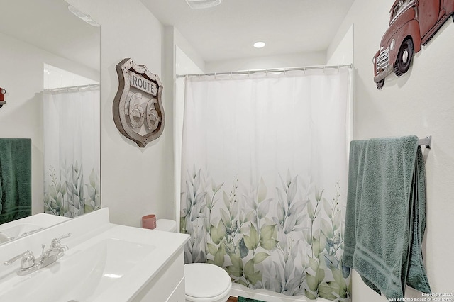 bathroom featuring curtained shower, vanity, and toilet