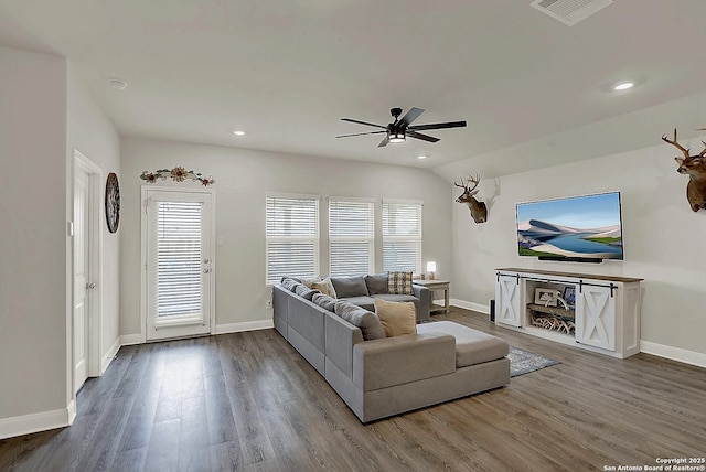 living room with a wealth of natural light, wood finished floors, visible vents, and baseboards