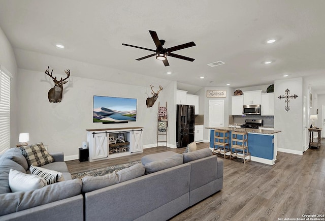 living area featuring wood finished floors, visible vents, and baseboards