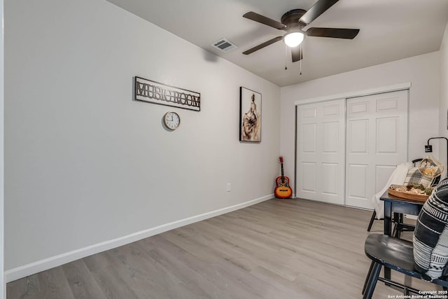 living area with visible vents, baseboards, ceiling fan, and wood finished floors