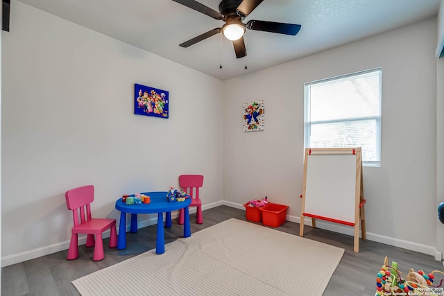 playroom with ceiling fan, baseboards, and wood finished floors