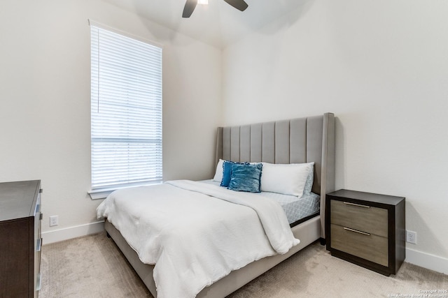 bedroom with ceiling fan, baseboards, and light colored carpet