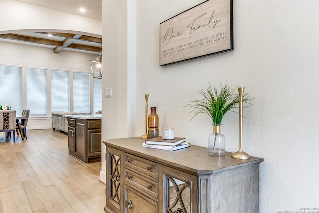 interior space with coffered ceiling, beamed ceiling, light wood-style flooring, and baseboards