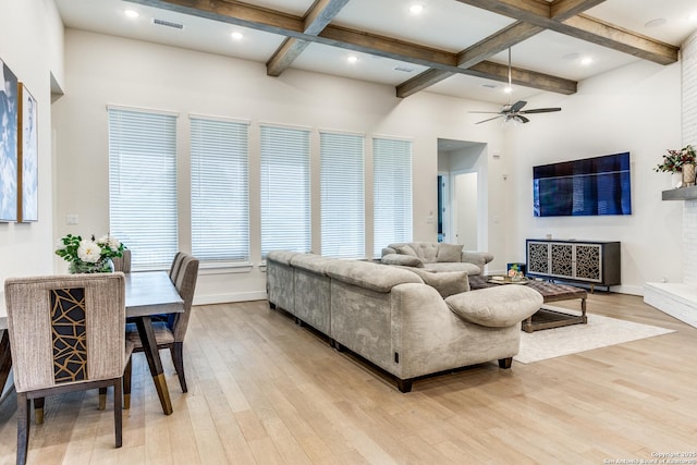 living room with beam ceiling, coffered ceiling, baseboards, and light wood finished floors