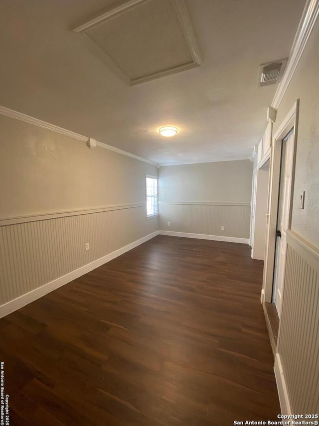 spare room featuring a wainscoted wall, dark wood-style floors, and visible vents