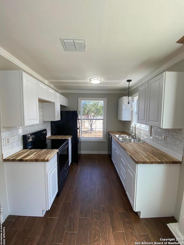 kitchen featuring butcher block counters, dark wood-style flooring, a sink, visible vents, and black appliances