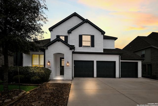 view of front of property with a garage, brick siding, and driveway