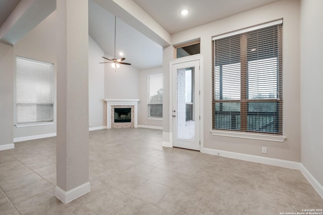 unfurnished living room with lofted ceiling, light tile patterned floors, a fireplace, and baseboards