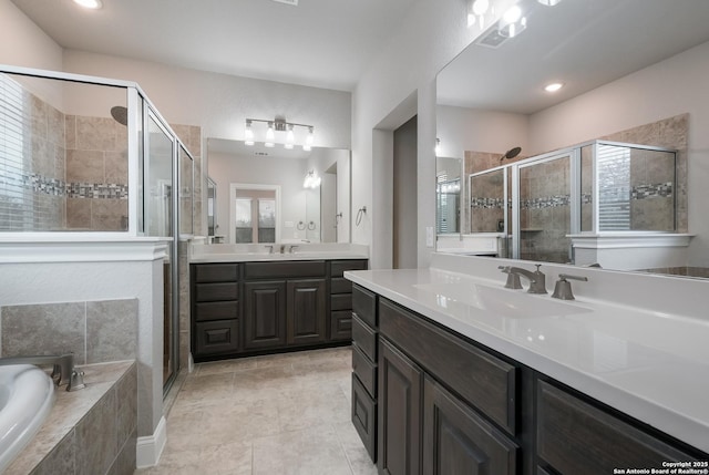 bathroom featuring a garden tub, two vanities, a sink, and a shower stall