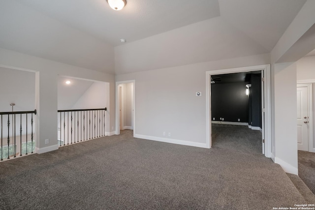 carpeted empty room with baseboards and vaulted ceiling