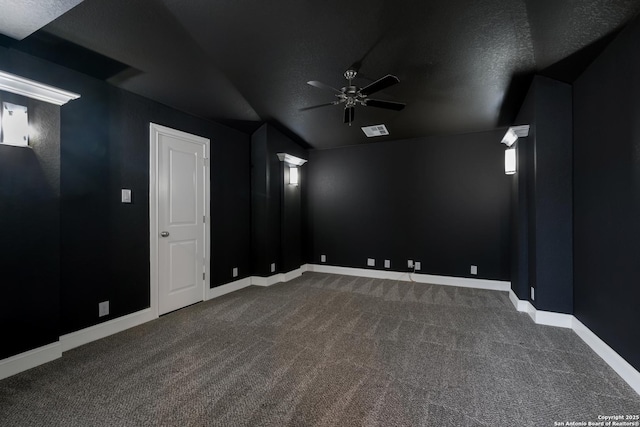 carpeted empty room featuring ceiling fan, a textured ceiling, lofted ceiling, visible vents, and baseboards