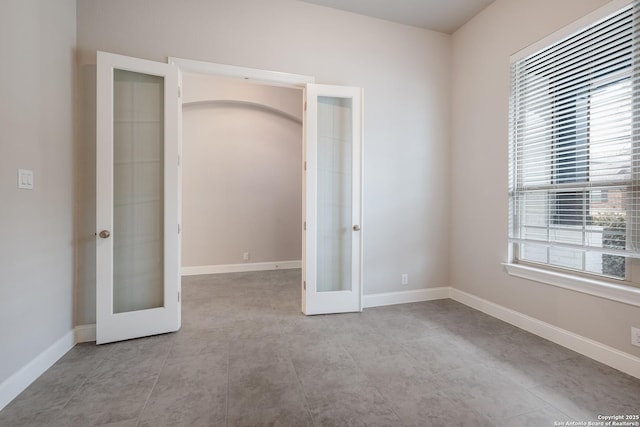 unfurnished bedroom with french doors and baseboards