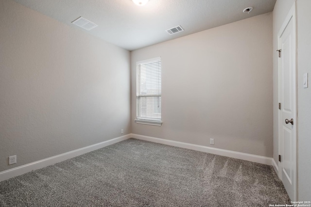 carpeted empty room featuring baseboards and visible vents