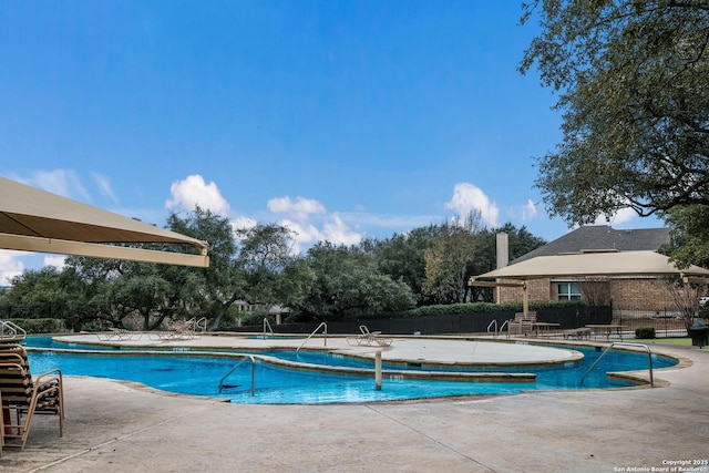 community pool featuring a patio area and fence