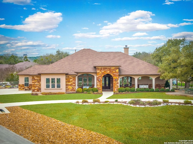 view of front of home with a chimney, stucco siding, concrete driveway, a front yard, and stone siding