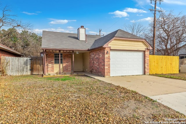 view of front of property with a garage, brick siding, and fence