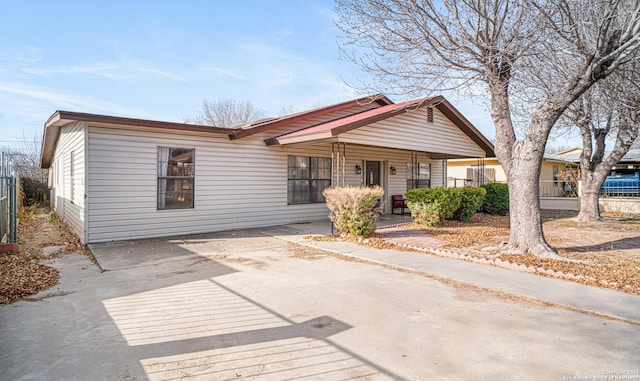 view of front of house with fence, a porch, and concrete driveway