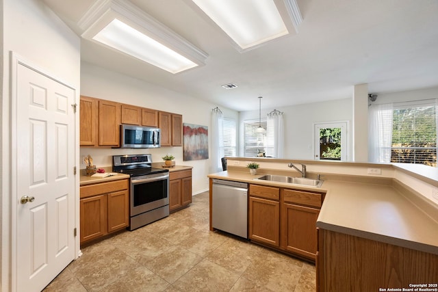 kitchen with stainless steel appliances, brown cabinetry, and a sink