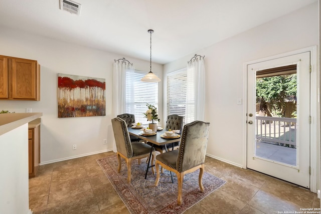 dining room featuring plenty of natural light, visible vents, and baseboards