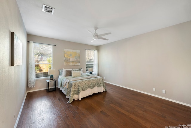 bedroom with wood-type flooring, visible vents, and baseboards