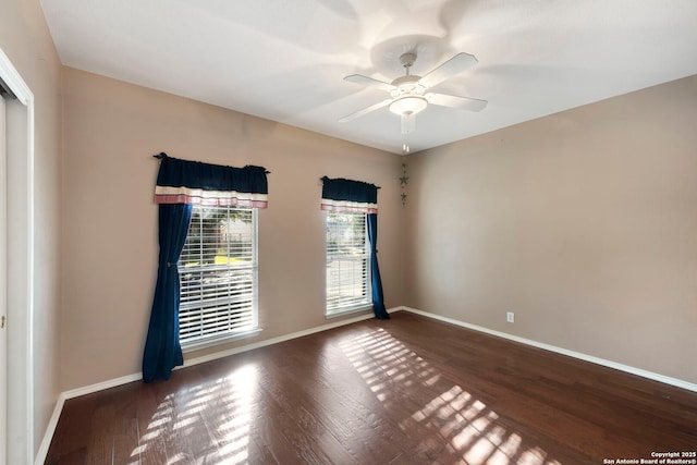 spare room with baseboards and wood finished floors