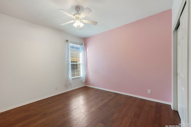 empty room with a ceiling fan, dark wood finished floors, and baseboards